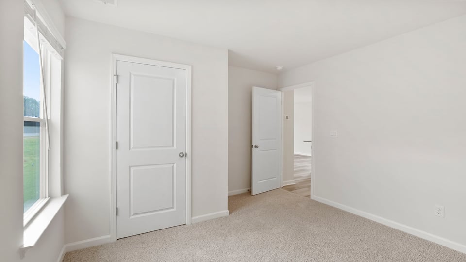 Bedroom with carpet and window.