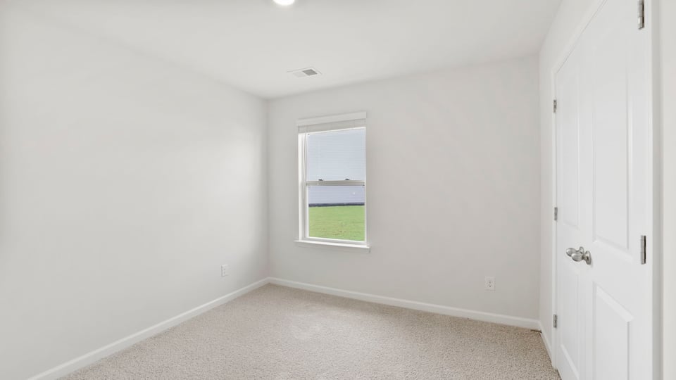Bedroom with carpet and window.
