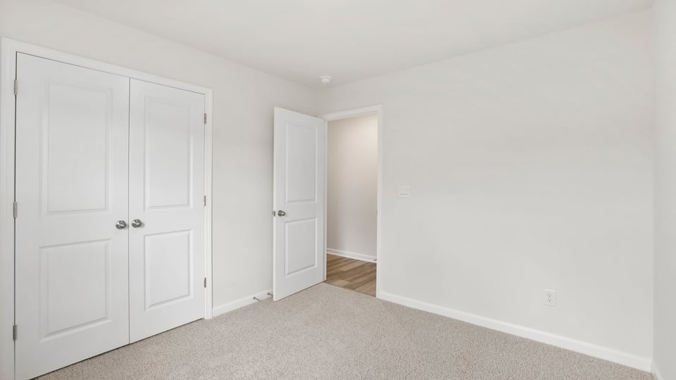 Bedroom with carpet and window.