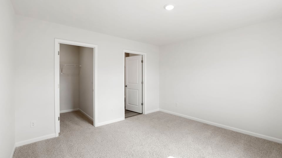 Bedroom with carpet and windows.