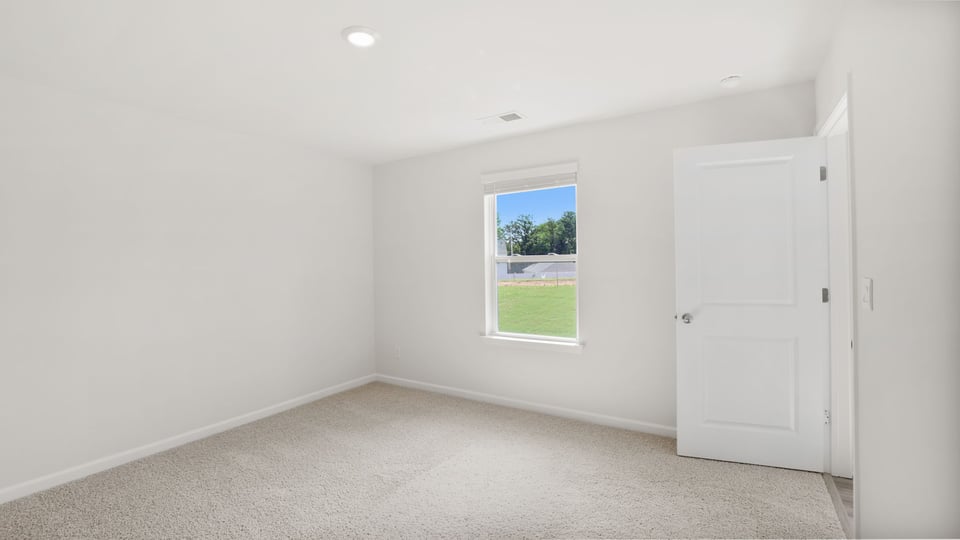 Bedroom with carpet and windows.