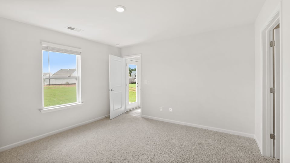 Bedroom with carpet and windows.