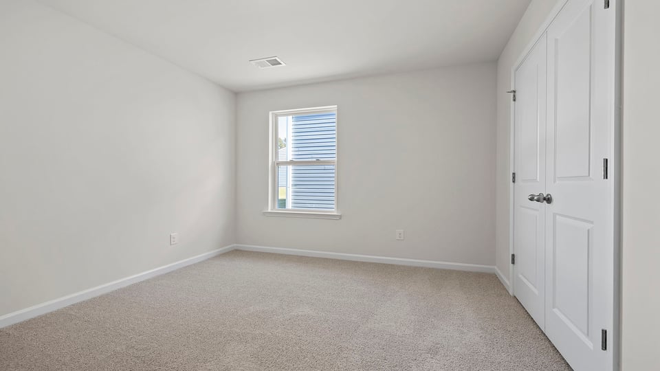 Bedroom with carpet and window.