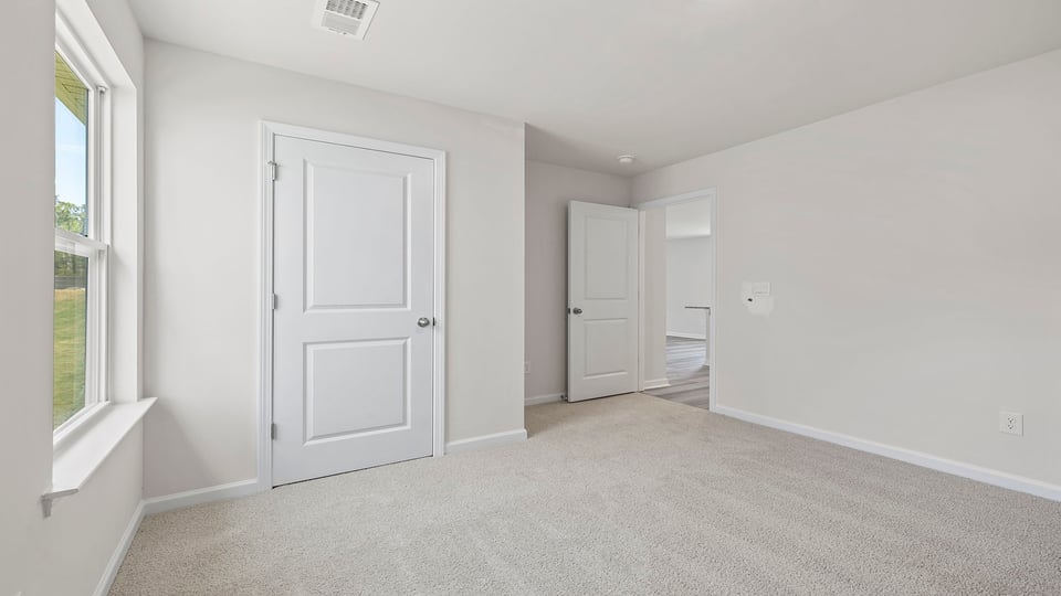 Bedroom with carpet and window.