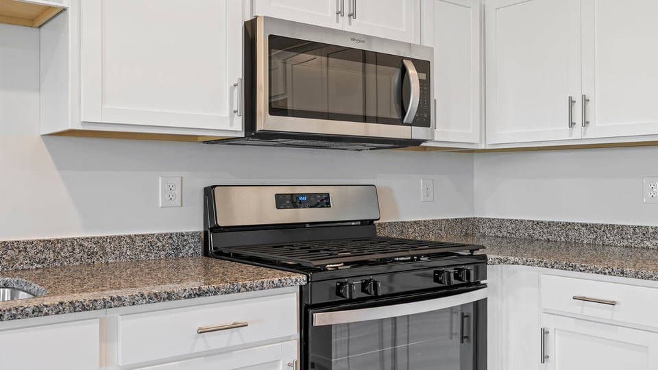 Kitchen with quartz countertops and stainless steel appliances.
