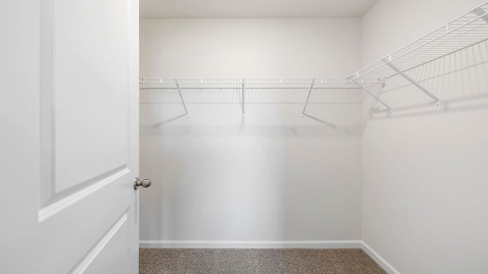 Walk in closet with hanging shelves.