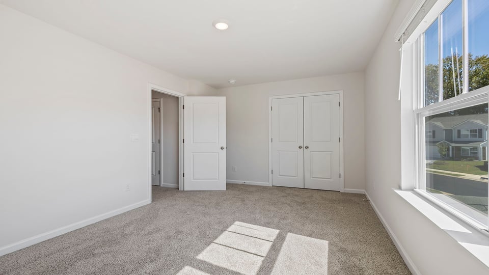 Bedroom with carpet and window.