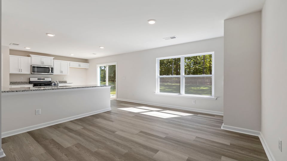 Dining room with windows and view of kitchen.
