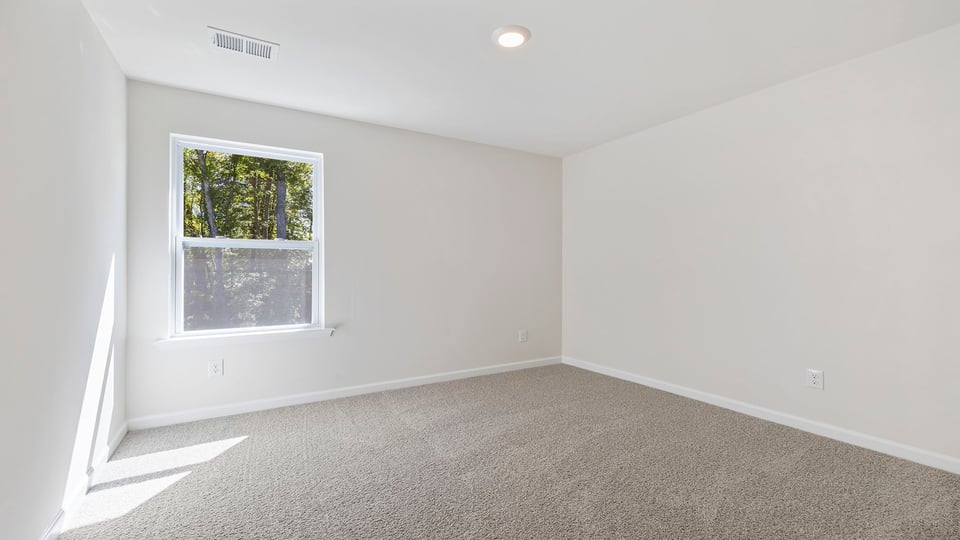 Bedroom with carpet and window.