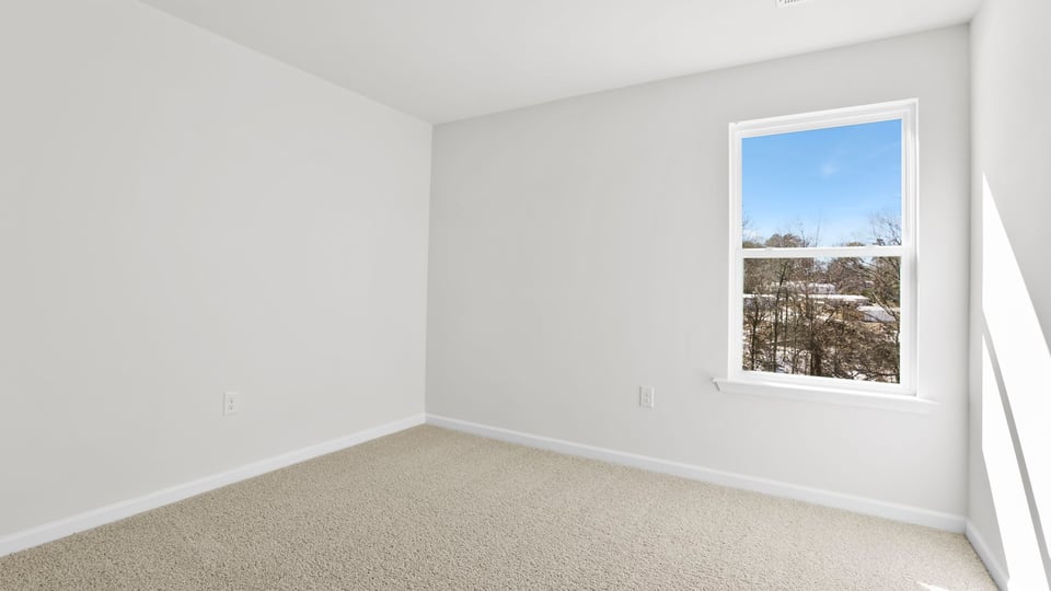 Bedroom with carpet and window.