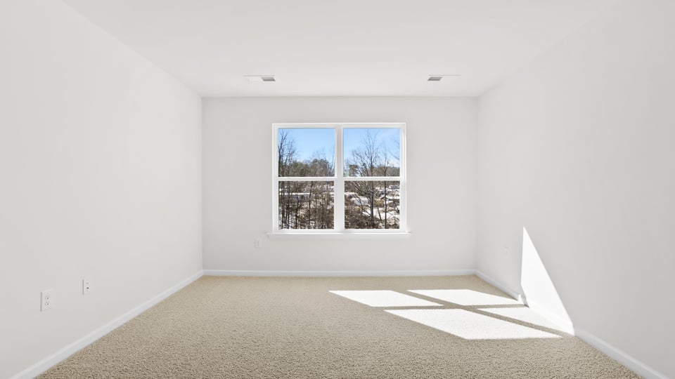 Bedroom with carpet and window.