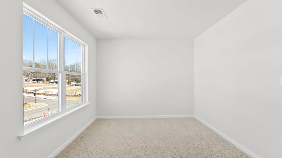 Bedroom with carpet and window.