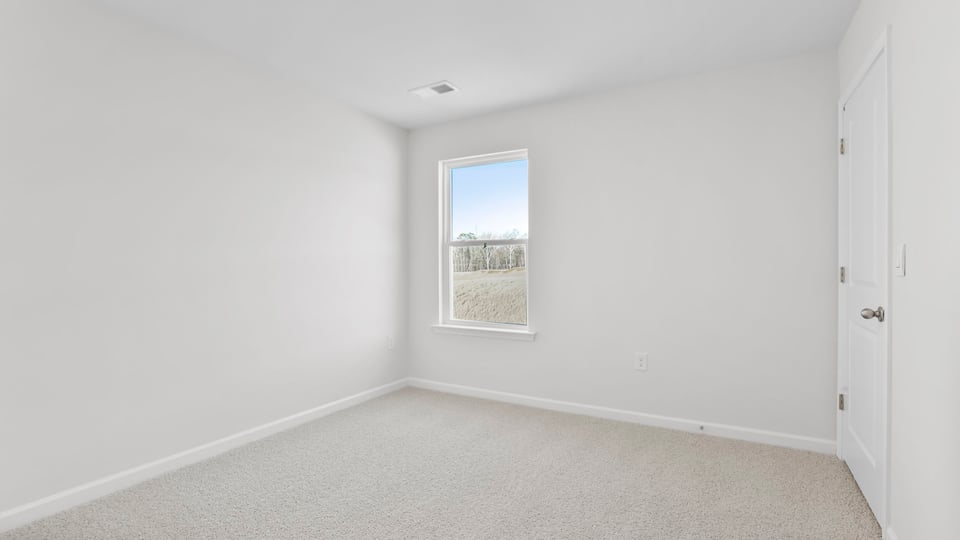 Bedroom with carpet and window.