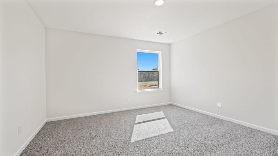 Bedroom with carpet and window.
