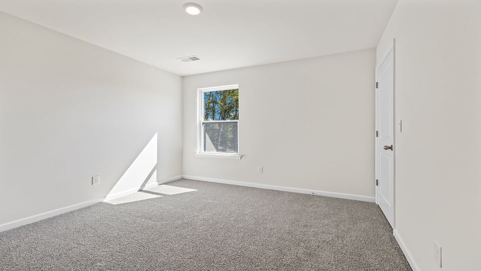 Bedroom with carpet and window.