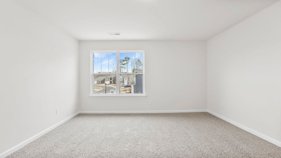 View of bedroom with window and carpet.