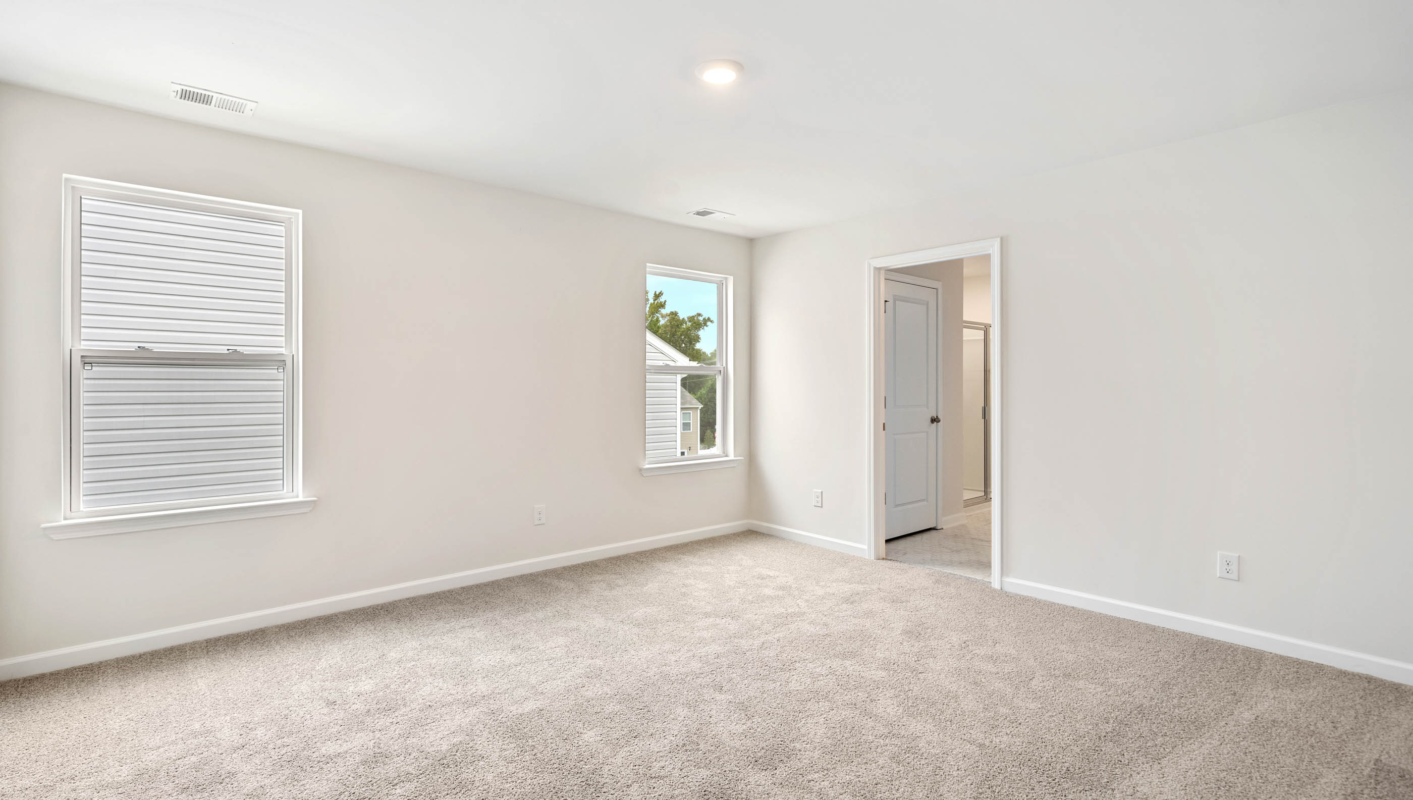 Room with carpet and large windows.