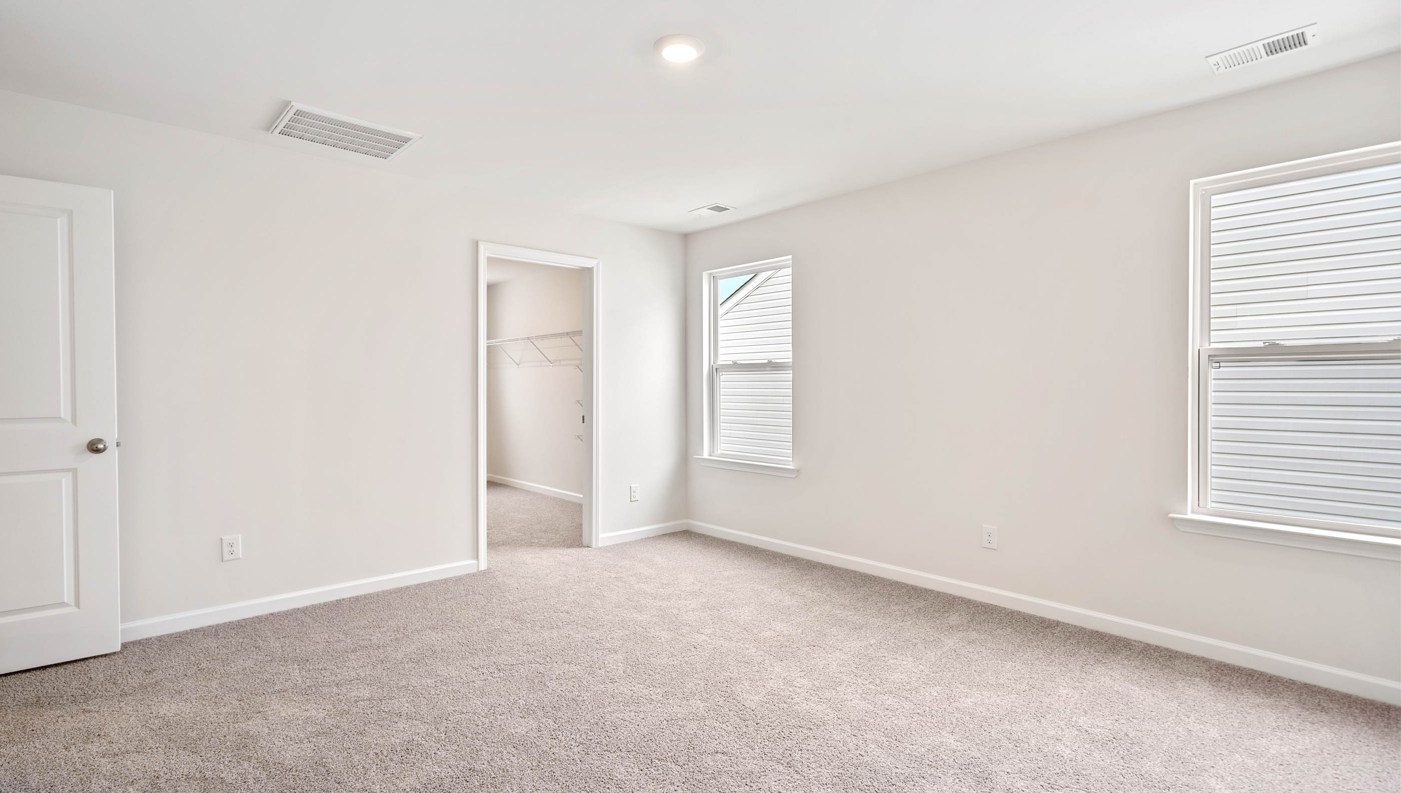 Room with carpet and large windows.