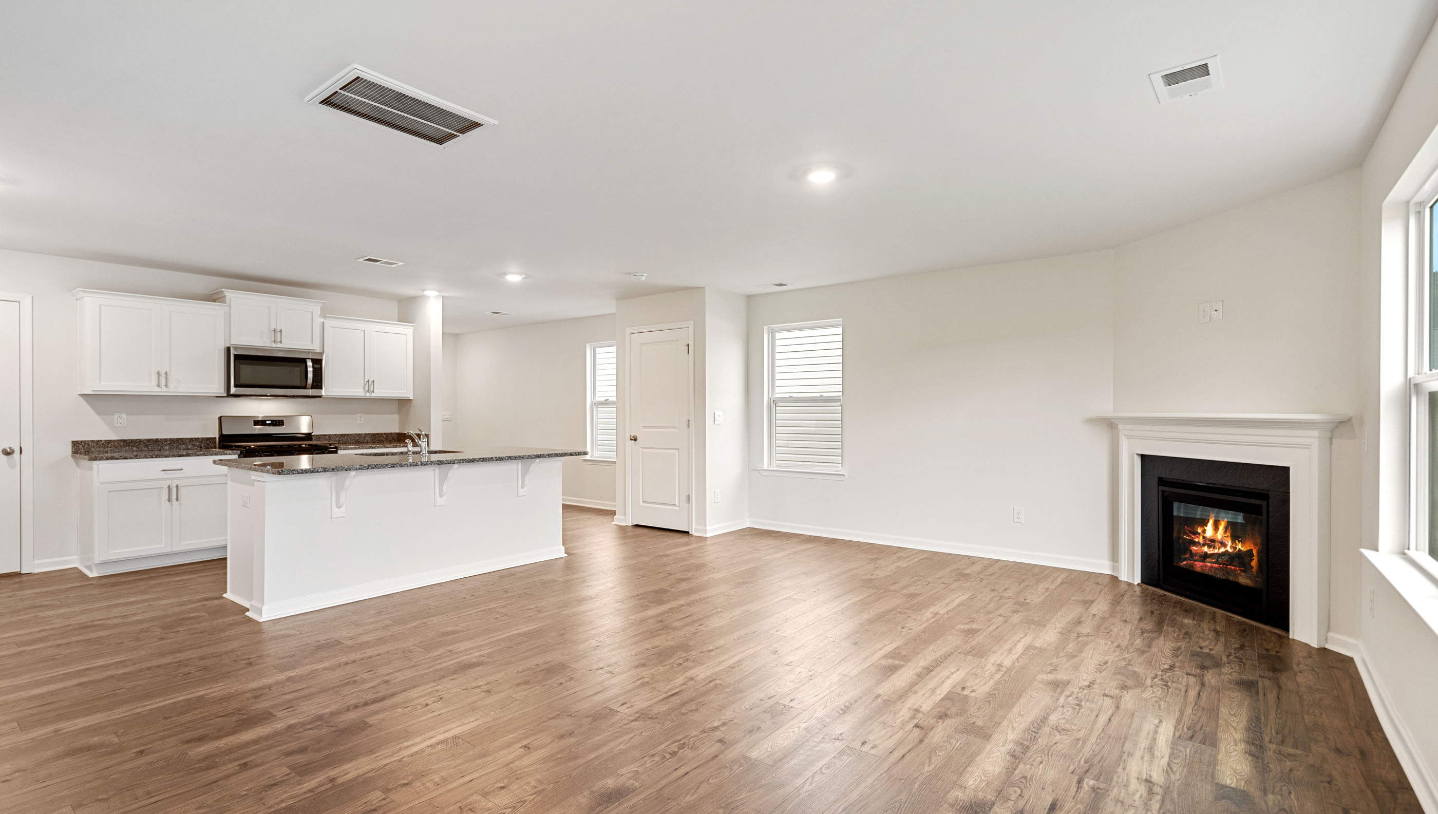 Family room with fireplace and view of kitchen.