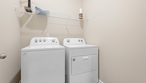 Laundry room with hanging storage racks.