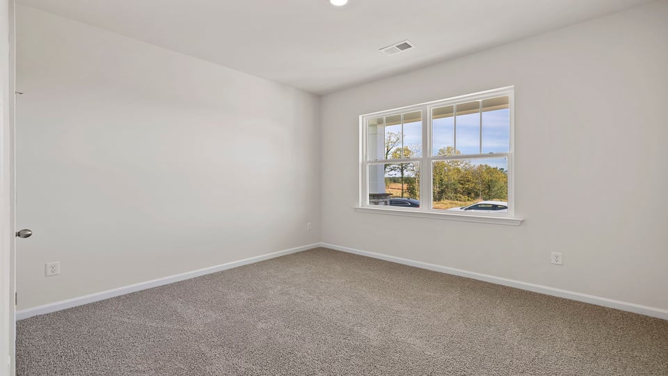 Bedroom with carpet and window.