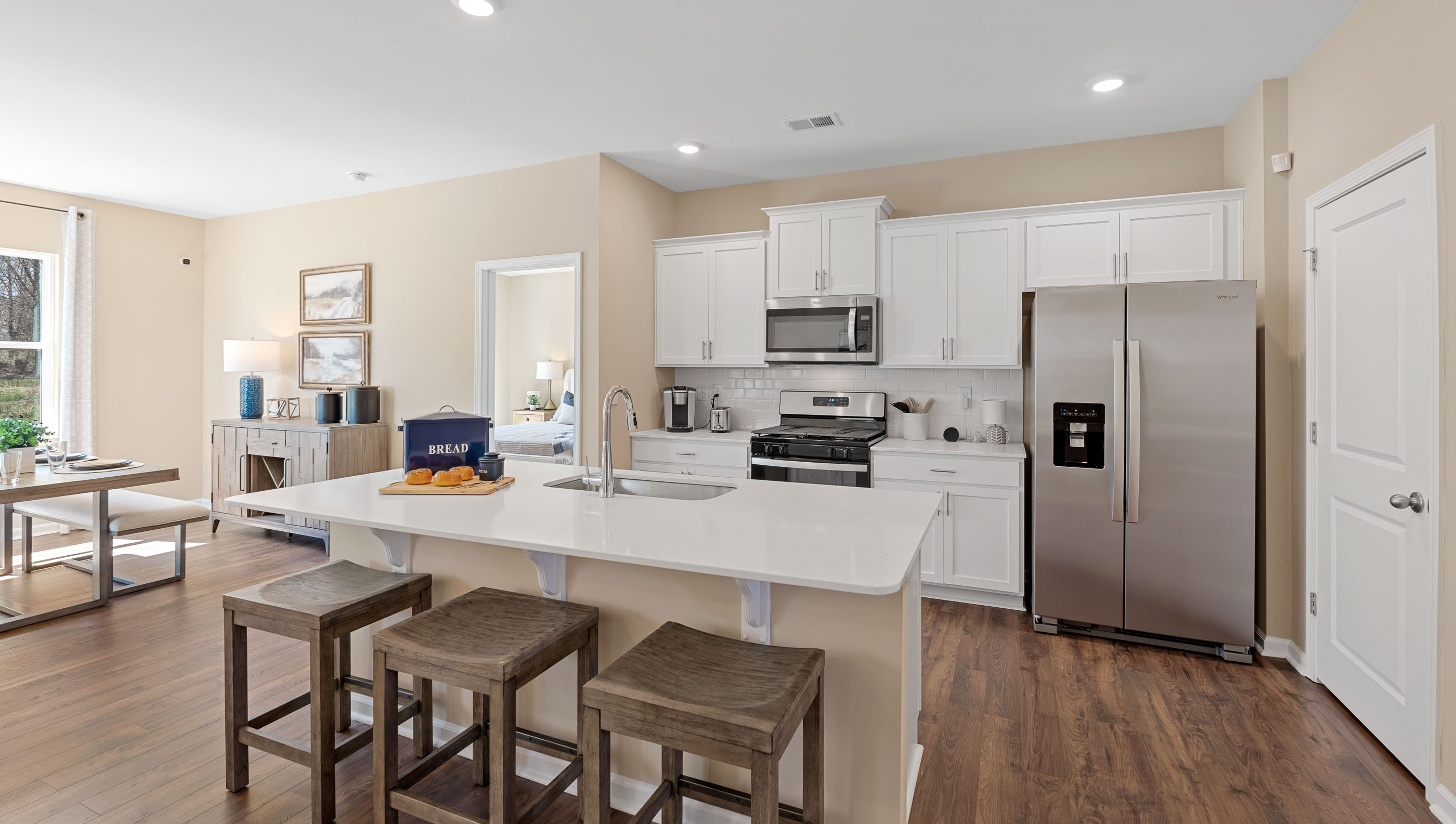 Kitchen and island with stainless steel appliances.
