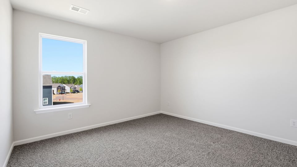 Bedroom with carpet and window.