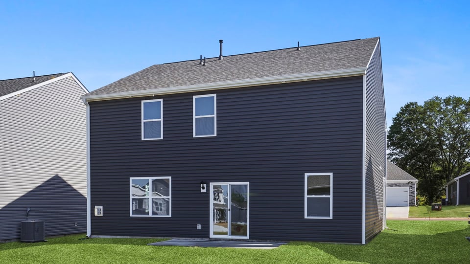 back exterior of home with large backyard.
