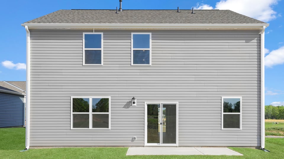 Back exterior of home with large backyard.