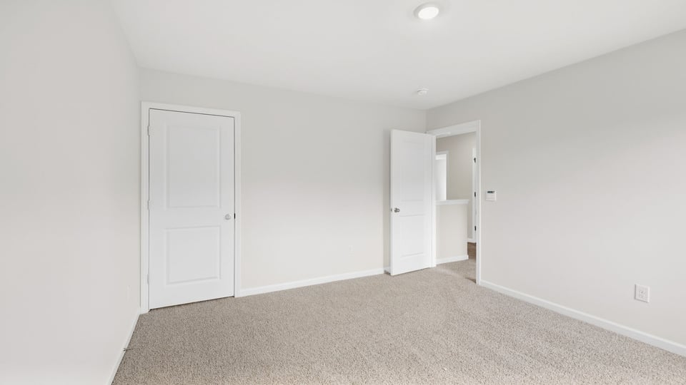 Bedroom with carpet and windows.