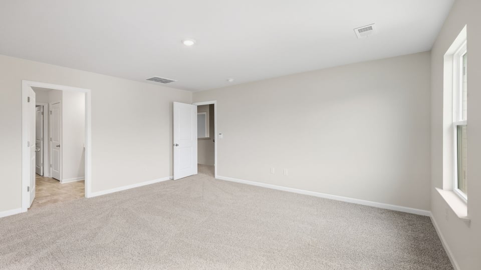 Bedroom with carpet and windows.