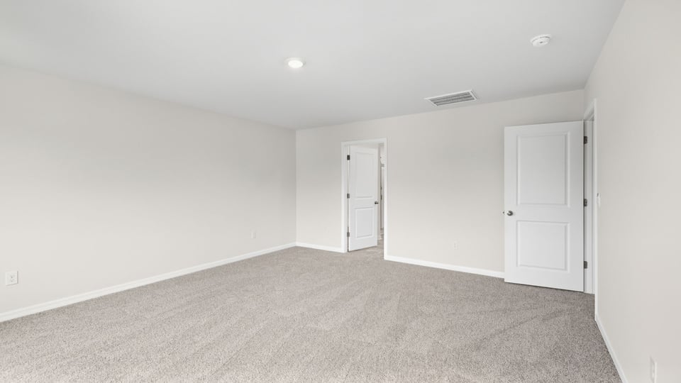 Bedroom with carpet and windows.