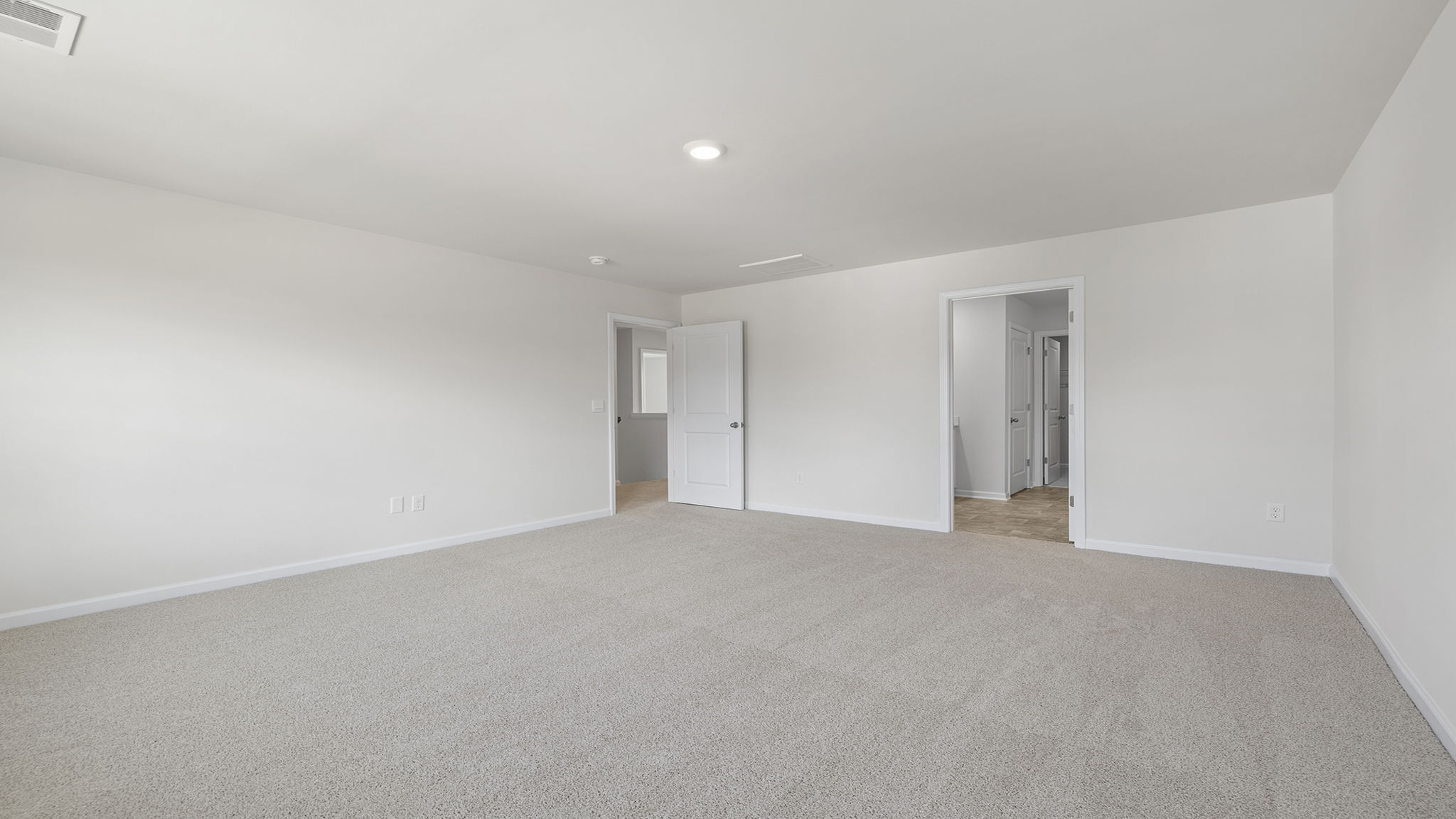 Primary bedroom with carpet and windows