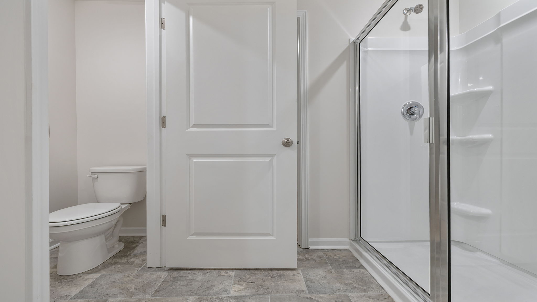 Primary bathroom with walk in shower and water closet.