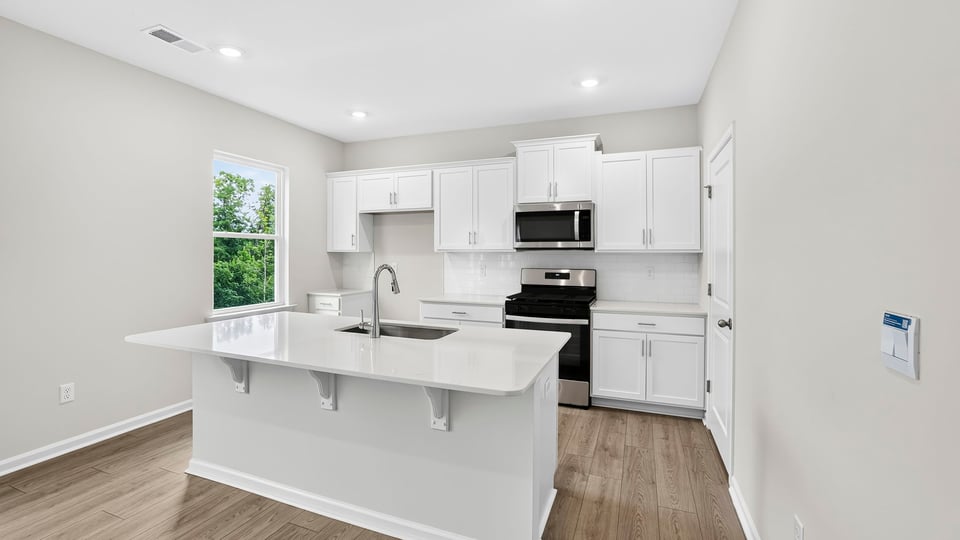 Kitchen and island with quartz countertops.