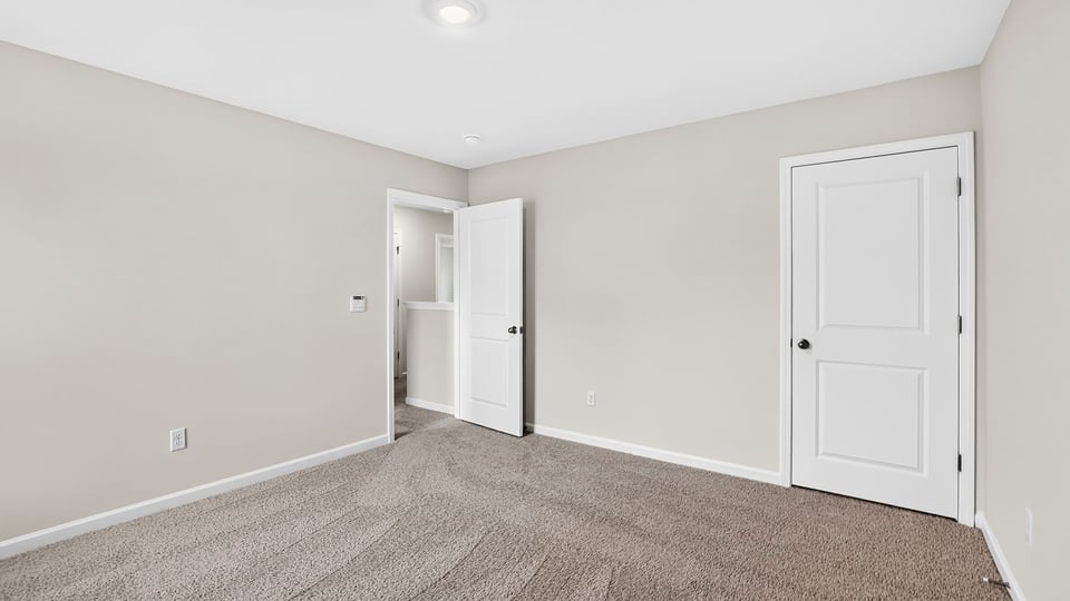 Bedroom with carpet and windows.
