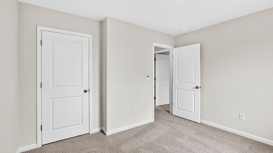 Bedroom with carpet and windows.