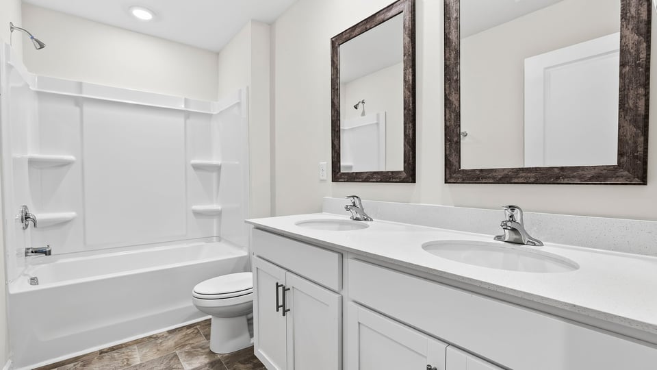 Bathroom with double vanity sink and tub.