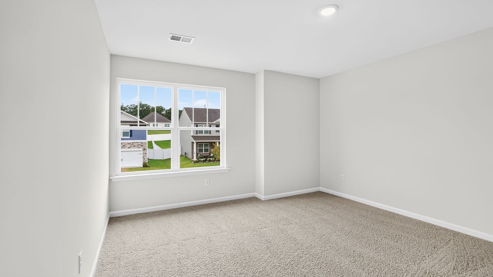 Bedroom with carpet and window.