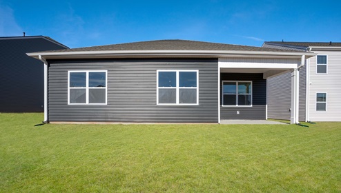 Back of home with large backyard.