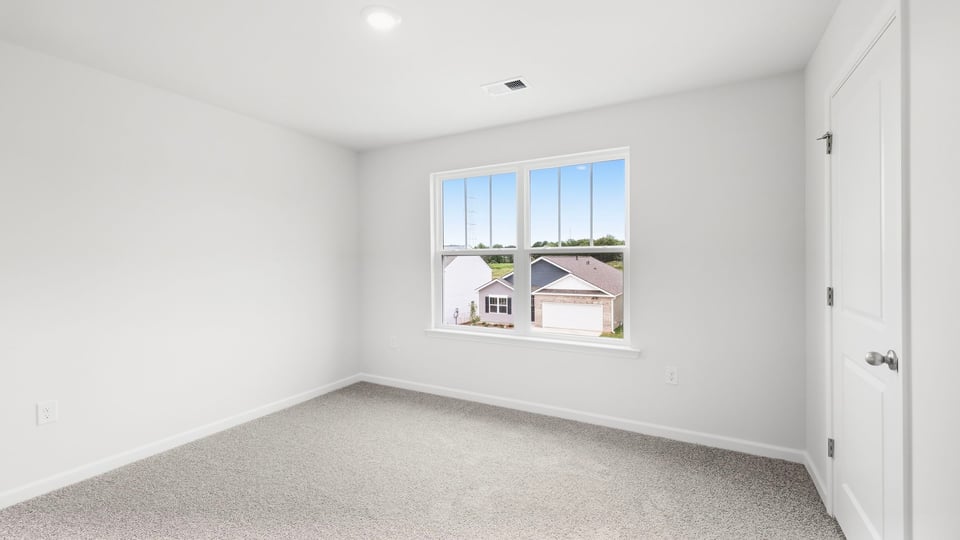 Bedroom with carpet and windows.