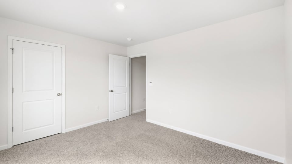 Bedroom with carpet and windows.