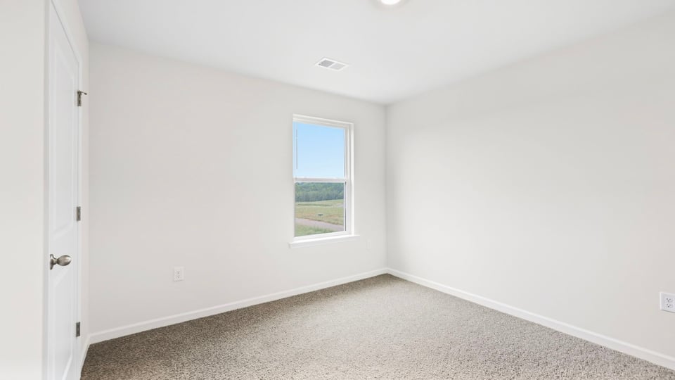 Bedroom with carpet and windows.