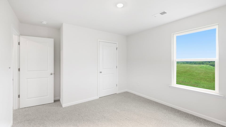 Bedroom with carpet and windows.