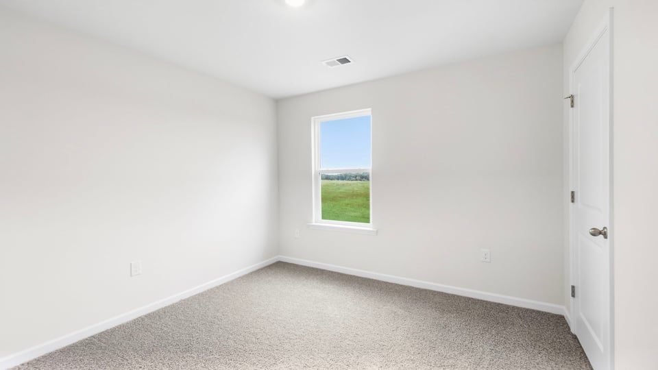 Bedroom with carpet and windows.