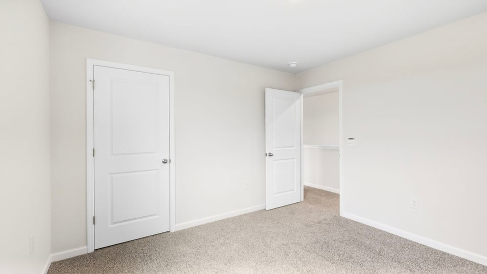 Bedroom with carpet and windows.