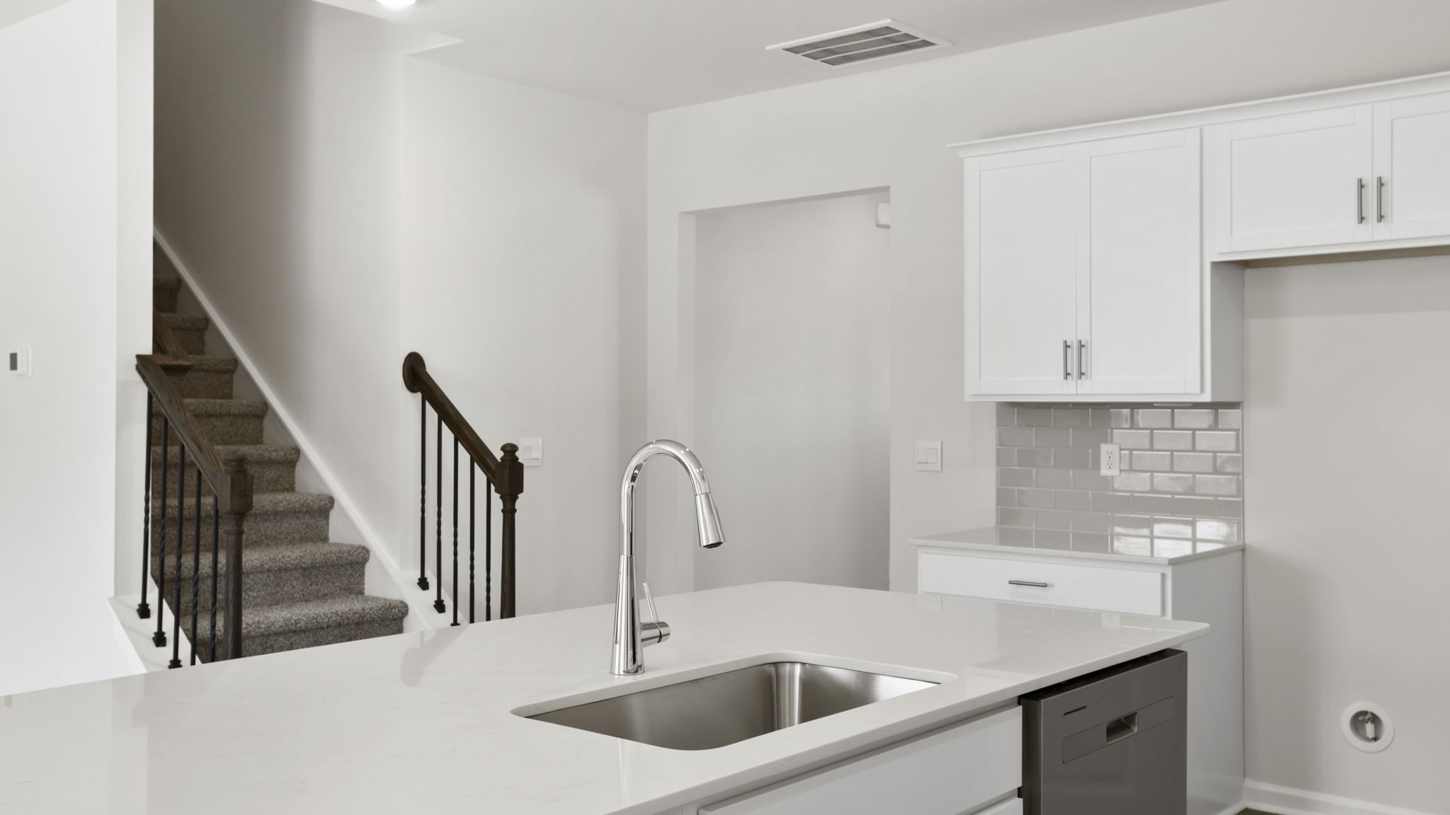 Kitchen and island with quartz countertops and stainless steel appliances.