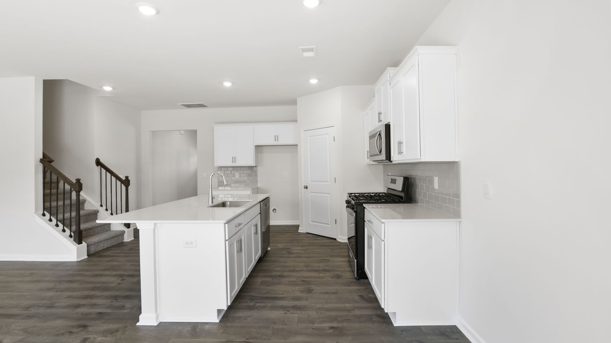 Kitchen and island with quartz countertops and stainless steel appliances.