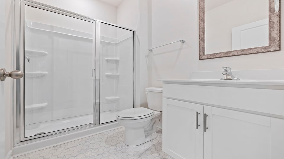 Bathroom with double sink vanity and walk in shower.
