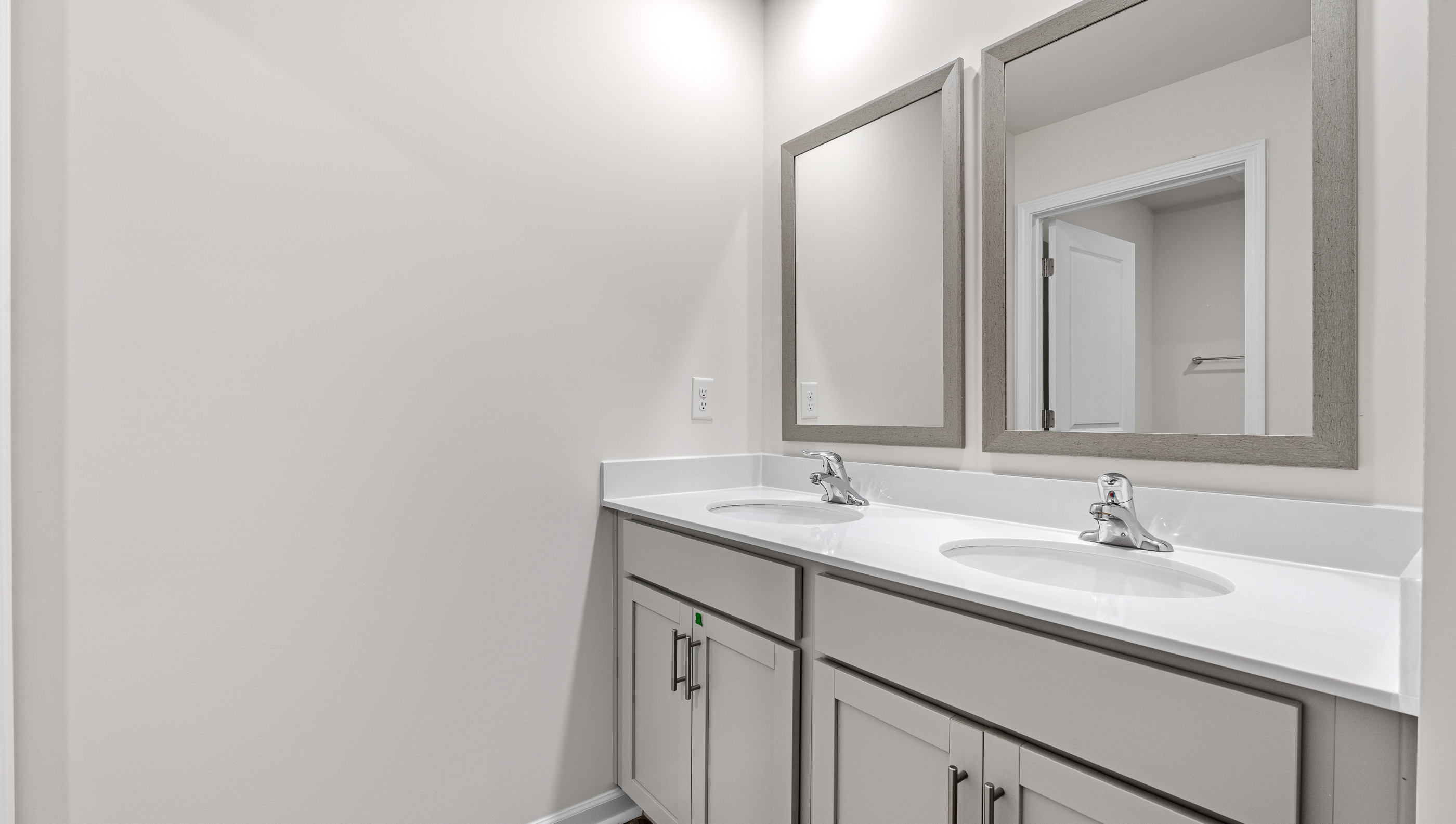 Hall bathroom with dual sink vanity and combination shower / tub.